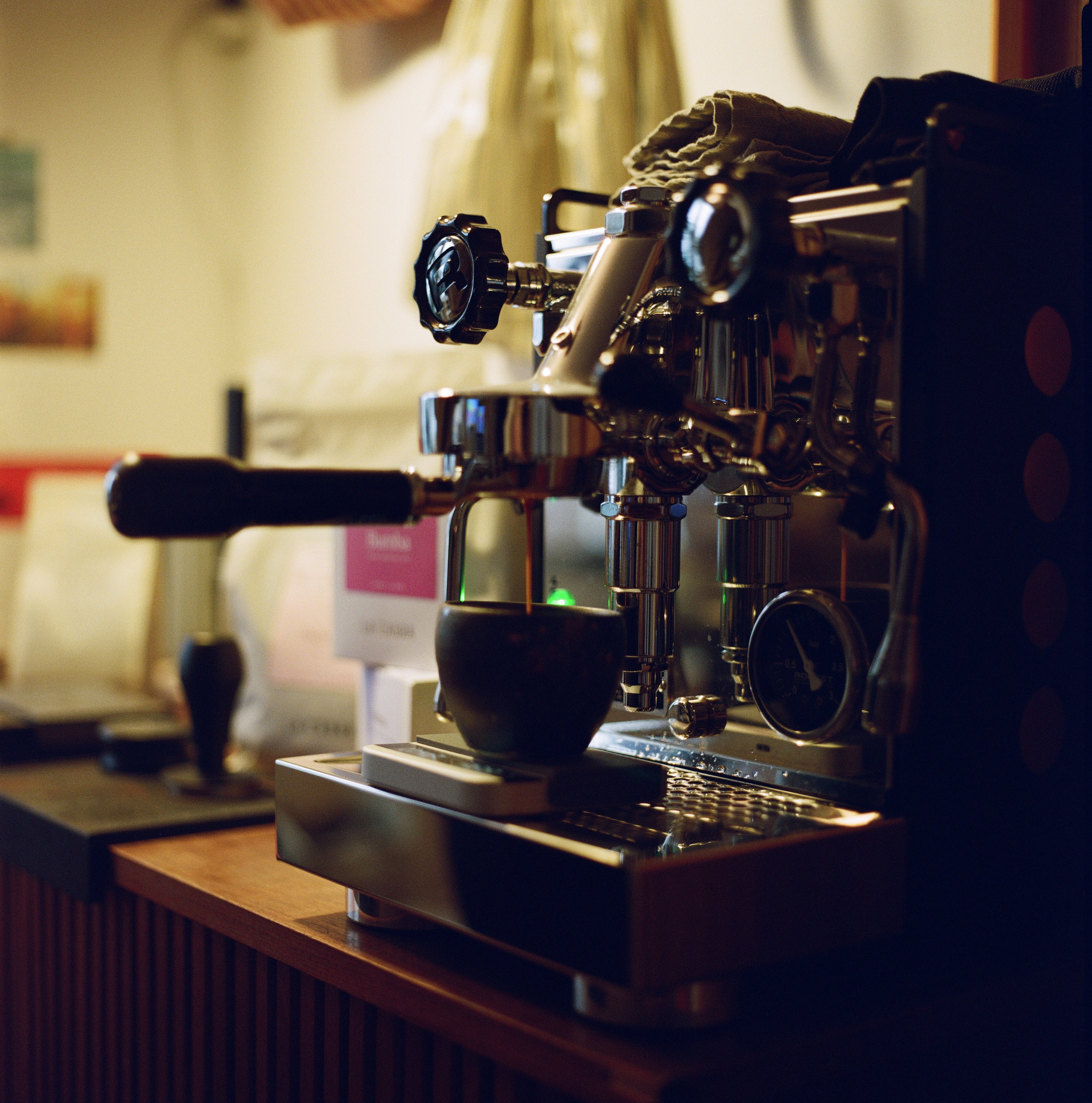 Espresso machine in a coffee shop with coffee being poured.
