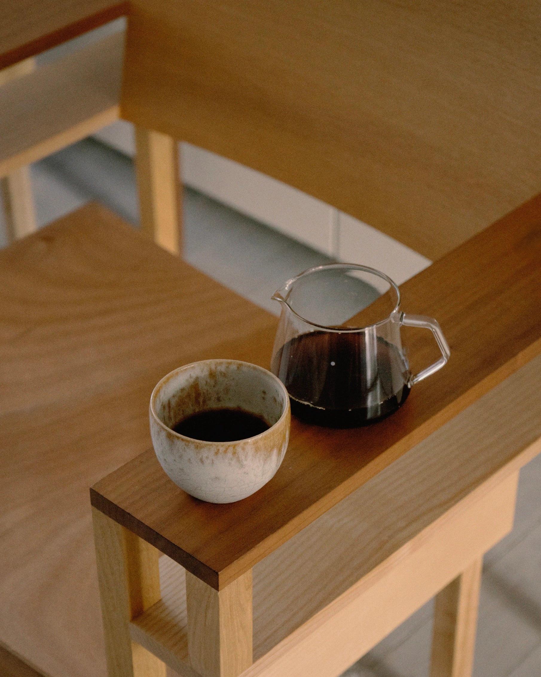Amber cup on wooden chair with Coffee in kinto